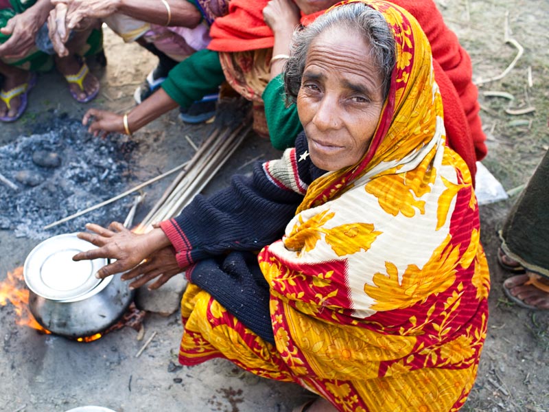 old bangladesh woman cooking on the ground